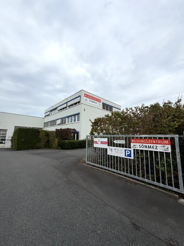 Gebäude mit Schriftzug Bildungszentrum Sönmez und Einfahrt mit Parkplatz-Schild
